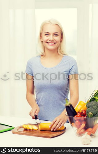 healthy eating, vegetarian food, cooking , dieting and people concept - smiling young woman chopping vegetables at home