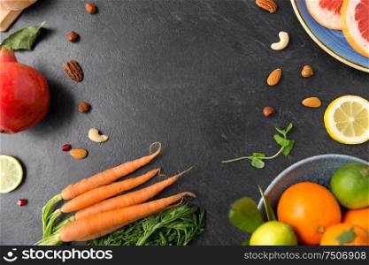 healthy eating, vegetarian food, diet and culinary concept - different vegetables and fruits on on slate table. different vegetables and fruits on on slate table