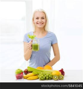 healthy eating, vegetarian food, diet, detox and people concept - smiling woman drinking green vegetable juice or shake from glass at home