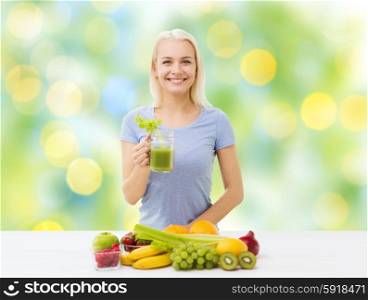healthy eating, vegetarian food, diet, detox and people concept - smiling woman drinking green vegetable juice or shake from glass over summer green holidays lights background