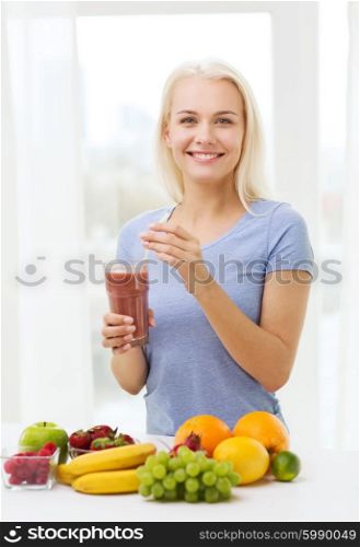 healthy eating, vegetarian food, diet, detox and people concept - smiling woman drinking fruit shake from glass at home