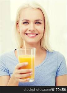 healthy eating, vegetarian food, diet, detox and people concept - smiling woman drinking orange juice or shake from glass at home