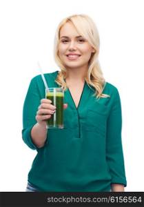 healthy eating, vegetarian food, diet, detox and people concept - smiling young woman drinking green vegetable juice or smoothie from glass