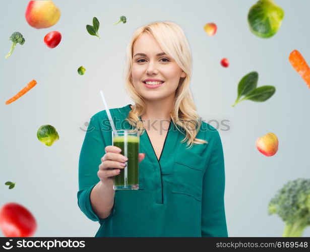 healthy eating, vegetarian food, diet, detox and people concept - smiling young woman drinking green vegetable juice or smoothie from glass over blue sky and clouds background