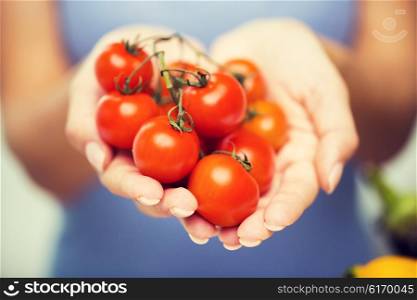 healthy eating, vegetarian food, diet , vegetables and people concept -close up of woman holding cherry tomatoes in hands