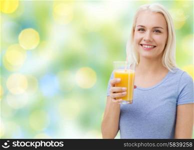 healthy eating, vegetarian food, dieting and people concept - smiling woman drinking orange juice or shake from glass over summer green holidays lights background