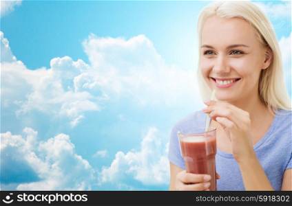 healthy eating, vegetarian food, dieting and people concept - smiling woman drinking juice or shake from glass over blue sky and clouds background