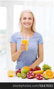 healthy eating, vegetarian food, dieting and people concept - smiling woman drinking fruit juice from glass at home
