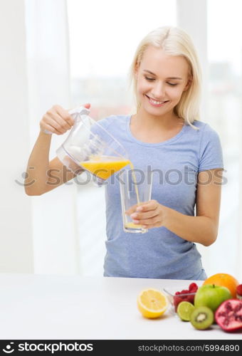 healthy eating, vegetarian food, dieting and people concept - smiling woman pouring fruit orange juice from jug to glass at home