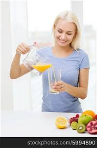 healthy eating, vegetarian food, dieting and people concept - smiling woman pouring fruit orange juice from jug to glass at home