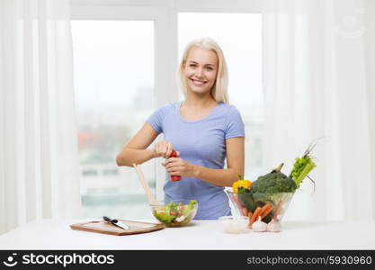 healthy eating, vegetarian food, dieting and people concept - smiling young woman cooking vegetable salad at home