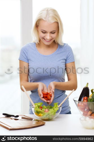 healthy eating, vegetarian food, dieting and people concept - smiling young woman cooking vegetable salad at home