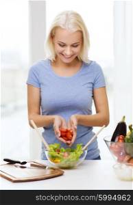 healthy eating, vegetarian food, dieting and people concept - smiling young woman cooking vegetable salad at home