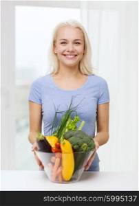 healthy eating, vegetarian food, dieting and people concept - smiling young woman with bowl of vegetables at home