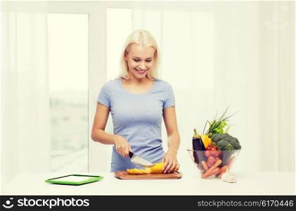 healthy eating, vegetarian food, dieting and people concept - smiling young woman cooking vegetables with tablet pc computer at home