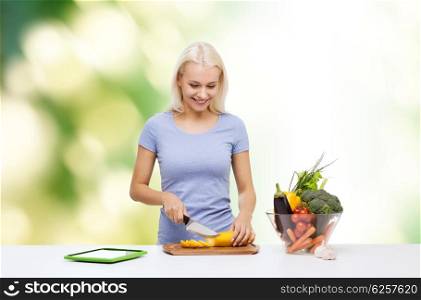 healthy eating, vegetarian food, dieting and people concept - smiling young woman cooking vegetables with tablet pc computer over green natural background