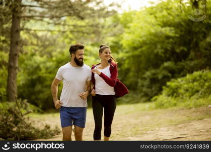 Healthy fit and sportive couple running in nature at summer day