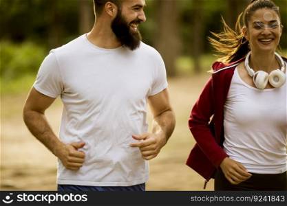 Healthy fit and sportive couple running in nature at summer day