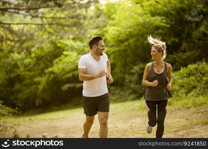 Healthy fit and sportive couple running in nature at summer day