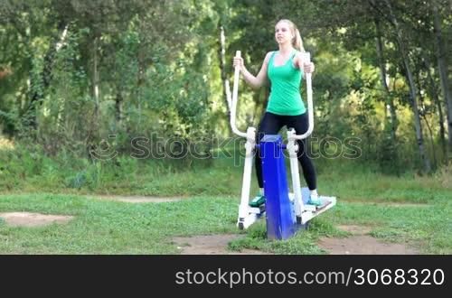 Healthy fit young woman exercising on a trainer in the garden
