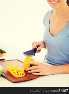healthy food and kitchen concept - woman hands cutting vegetables