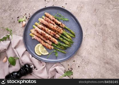 Healthy food - Asparagus wrapped with bacon and spices on a plate.. Healthy food - Asparagus wrapped with bacon and spices on a plate
