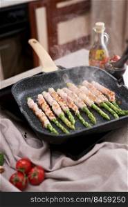 Healthy food - Asparagus wrapped with bacon and spices on grill pan.. Healthy food - Asparagus wrapped with bacon and spices on grill pan