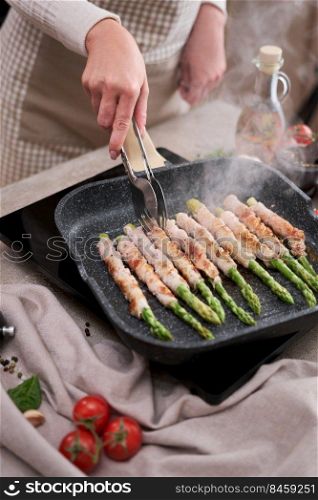 Healthy food - Asparagus wrapped with bacon and spices on grill pan.. Healthy food - Asparagus wrapped with bacon and spices on grill pan