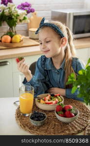 Healthy food at home. Cute little girl eats fruit salad 