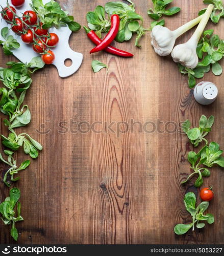 Healthy food background for recipes, menu or list with various fresh organic vegetables and condiment ingredients for salad or cooking on rustic wooden background, top view, frame.