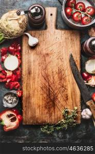 Healthy food background with aged cutting board, cooking pot ,vegetables and kitchen knife, top view, frame