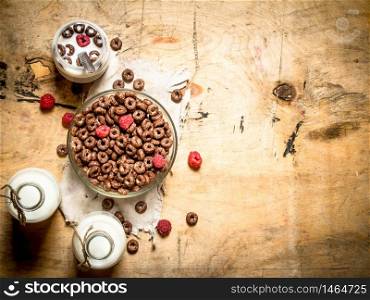 Healthy food. Chocolate cereal with raspberries and milk. On wooden background.. Healthy food. Chocolate cereal with raspberries and milk.