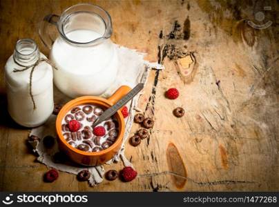 Healthy food. Chocolate cereal with raspberries and milk. On wooden background.. Healthy food. Chocolate cereal with raspberries and milk.