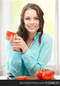 healthy food concept - beautiful woman in the kitchen with tomatoes