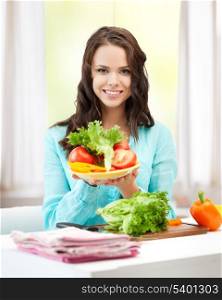 healthy food concept - beautiful woman in the kitchen with vegetables