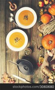 Healthy food cooking background. Vegetable ingredients and homemade soup. Fresh garden carrots, onions, pumpkins, ginger and spices on rustic wooden background, top view, copy space. Vegetable or pumpkin soup and ingredients. Vegetable ingredients and homemade soup.