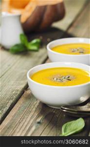 Healthy food cooking background. Vegetable ingredients and homemade soup. Fresh garden carrots, onions, pumpkins, ginger and spices on rustic wooden background. Healthy food cooking background. Vegetable ingredients and homemade soup.