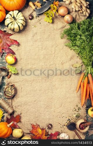 Healthy food cooking background. Vegetable ingredients. Fresh garden carrots, onions, pumpkins, ginger and spices on rustic wooden background, top view, copy space