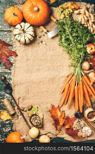 Healthy food cooking background. Vegetable ingredients. Fresh garden carrots, onions, pumpkins, ginger and spices on rustic wooden background, top view, copy space. Healthy food cooking background, space for your text