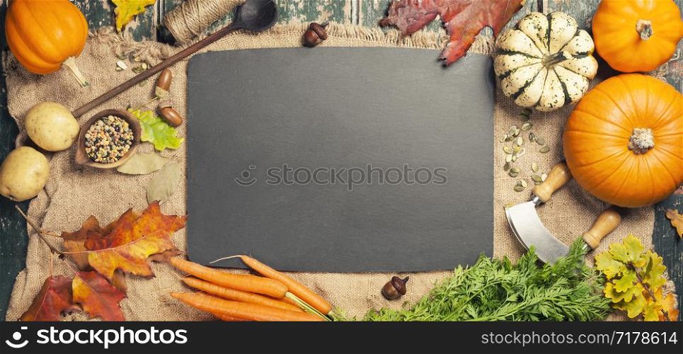 Healthy food cooking background. Vegetable ingredients. Fresh garden carrots, onions, pumpkins, ginger and spices on rustic wooden background, top view, copy space. Healthy food cooking background, space for text