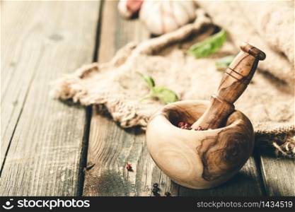 Healthy food cooking background. Wooden mortar and pestle, herbs and spices, copy space