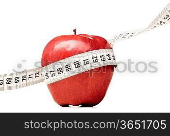 healthy food. Delicious apple with measuring tape on red background