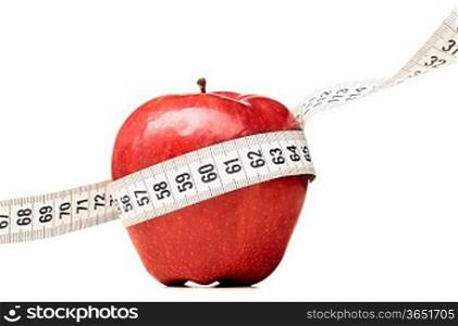 healthy food. Delicious apple with measuring tape on red background