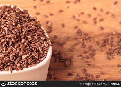 Healthy food diet. Brown flax seeds linseed in white bowl on wooden table