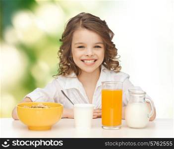 healthy food, eating, people and children concept - happy smiling beautiful girl having breakfast over green background