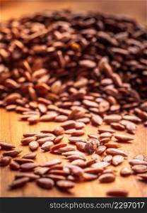 Healthy food for preventing heart diseases and overweight. Flax seeds linseed heap closeup on wood background