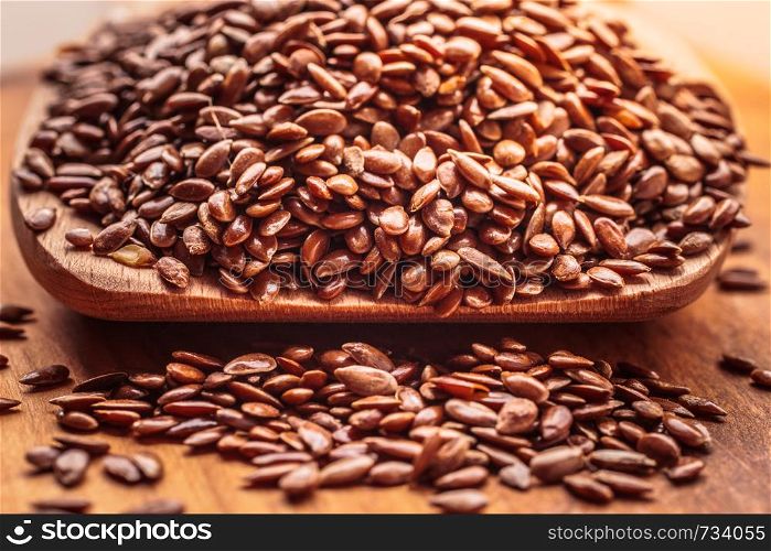 Healthy food for preventing heart diseases and overweight. Flax seeds linseed on wooden spoon wood background