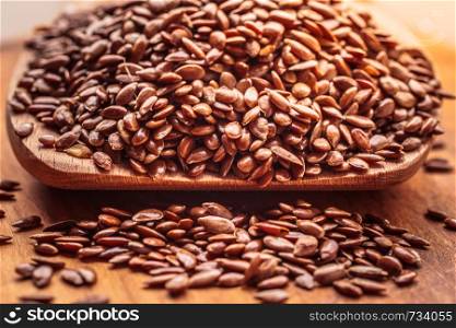 Healthy food for preventing heart diseases and overweight. Flax seeds linseed on wooden spoon wood background