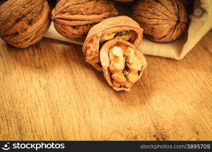 Healthy food full of omega-3 fatty acids, organic nutrition. Walnut kernels and whole on rustic old wooden table