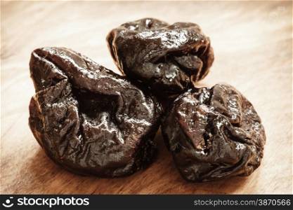 Healthy food, good cuisine. Closeup dried plums prunes fruits on wooden rustic table background